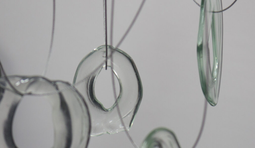 Doughnut shaped clear glass forms dangling from looped wires