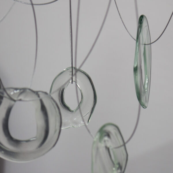 Doughnut shaped clear glass forms dangling from looped wires